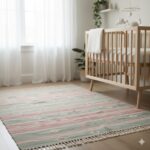 Soft pastel rug in dusty rose and sage green, ideal for a nursery.