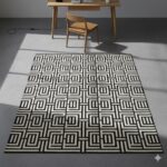 A bold, high-contrast, black and white rug with a complex interlocking geometric pattern.