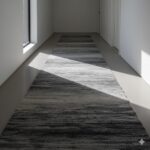 A modern hallway runner with a subtle, abstract pattern in various shades of grey.