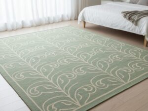 A serene and sophisticated area rug in soft sage green with elegant cream swirling patterns.