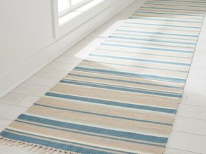 A coastal-themed hallway runner in sandy beige, sea blue, and white stripes.