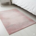 A soft and romantic accent rug with a gentle abstract pattern of dusty rose and grey.