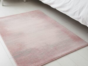 A soft and romantic accent rug with a gentle abstract pattern of dusty rose and grey.
